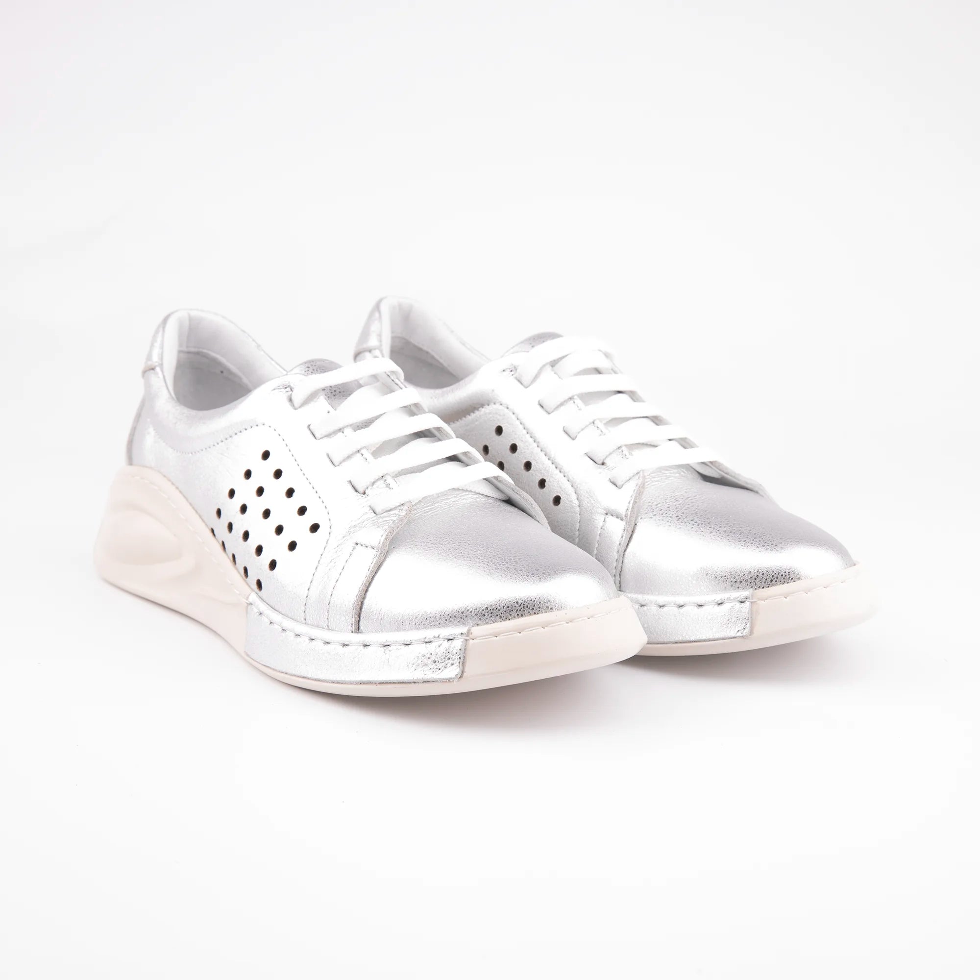 Pair of MrCalvano Laguna Beach women silver leather comfort shoes featuring a metallic silver upper, white laces, and a unique contoured sole against a white background.