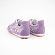Pair of MrCalvano women's lavender leather and suede sneakers with white wavy details and gum sole, back side-facing on white background.