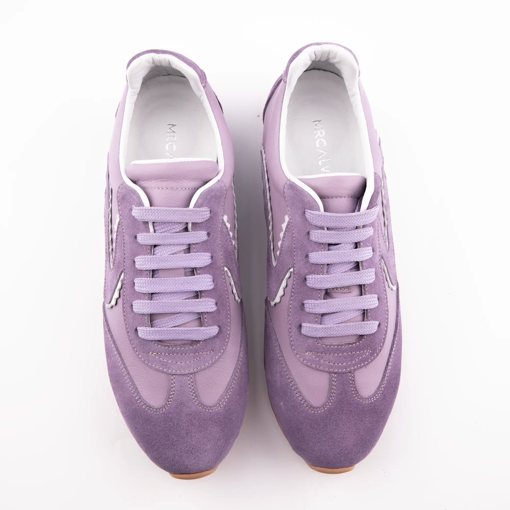 Pair of MrCalvano women's lavender leather and suede sneakers with white wavy details and gum sole, top-facing on white background.
