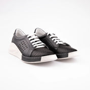 A pair of MrCalvano Marina Del Rey black leather comfort shoes featuring perforated uppers, white laces, and a sculpted white sole on a white background.