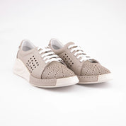 A pair of MrCalvano Marina Del Rey taupe leather comfort shoes for women. The shoes feature white laces, perforated detailing on the sides and toe box, and a subtle white wedge sole, presented on a clean white background.