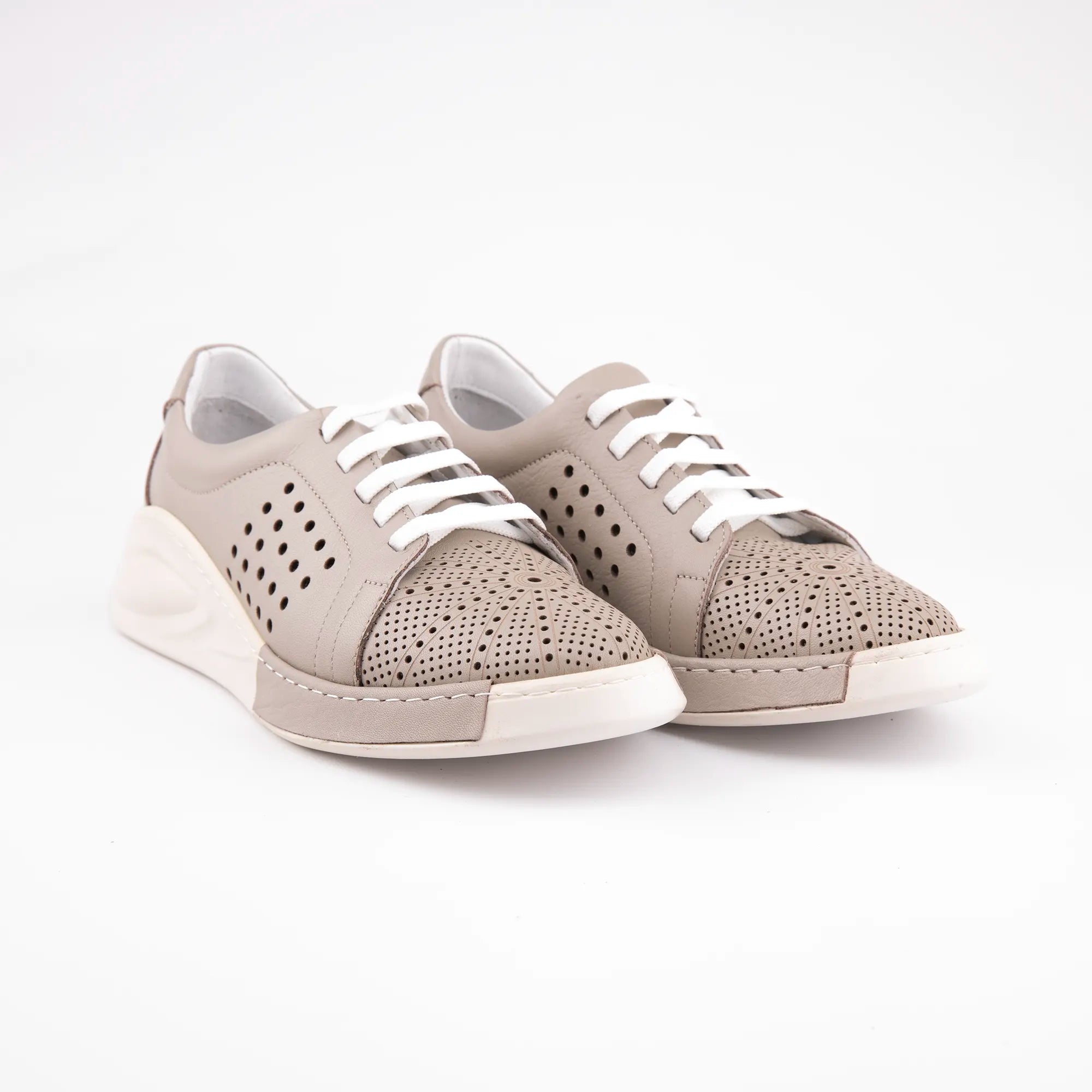 A pair of MrCalvano Marina Del Rey taupe leather comfort shoes for women. The shoes feature white laces, perforated detailing on the sides and toe box, and a subtle white wedge sole, presented on a clean white background.