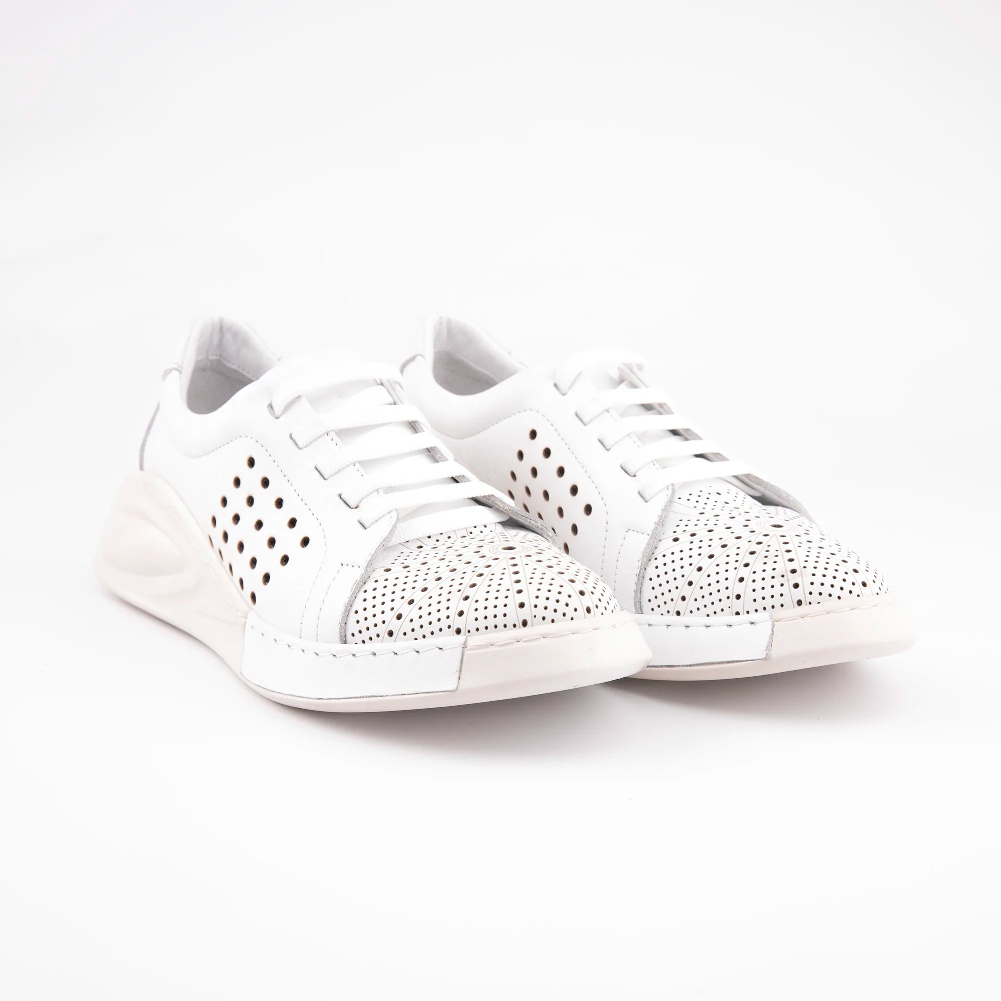 A studio shot of the MrCalvano Marina Del Rey white leather comfort shoes, emphasizing the delicate perforations, crisp white color, and refined shape. The image captures the shoe's understated elegance and robust construction, highlighting its potential for versatile styling in the United States.
