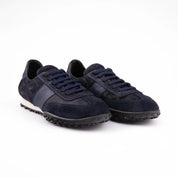 A close-up view of the MrCalvano Pebble Beach navy leather women's sneakers, highlighting the contrasting textures of the navy leather upper and the robust black rubber sole. The laces match the deep navy of the shoe body.usa