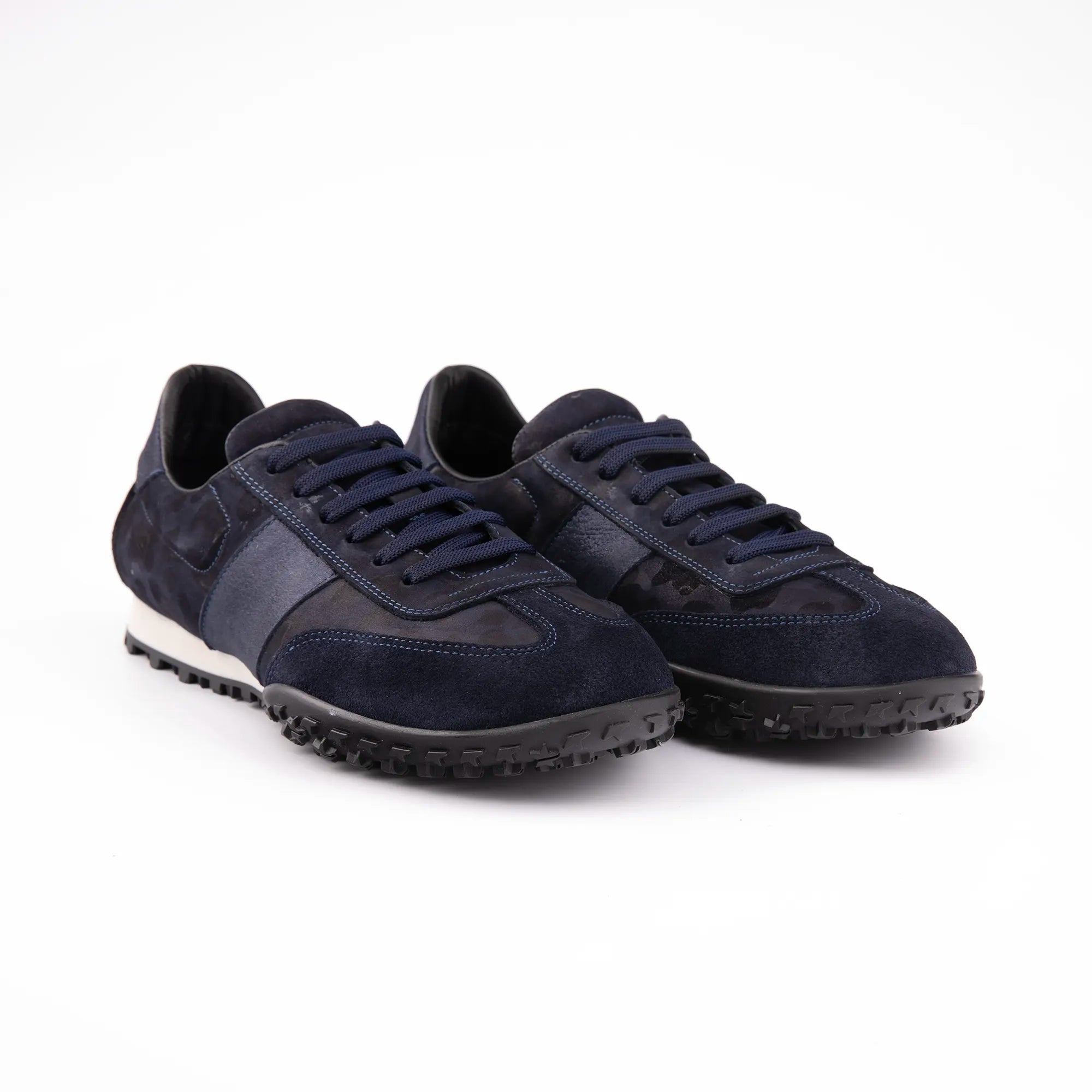 A close-up view of the MrCalvano Pebble Beach navy leather women's sneakers, highlighting the contrasting textures of the navy leather upper and the robust black rubber sole. The laces match the deep navy of the shoe body.usa