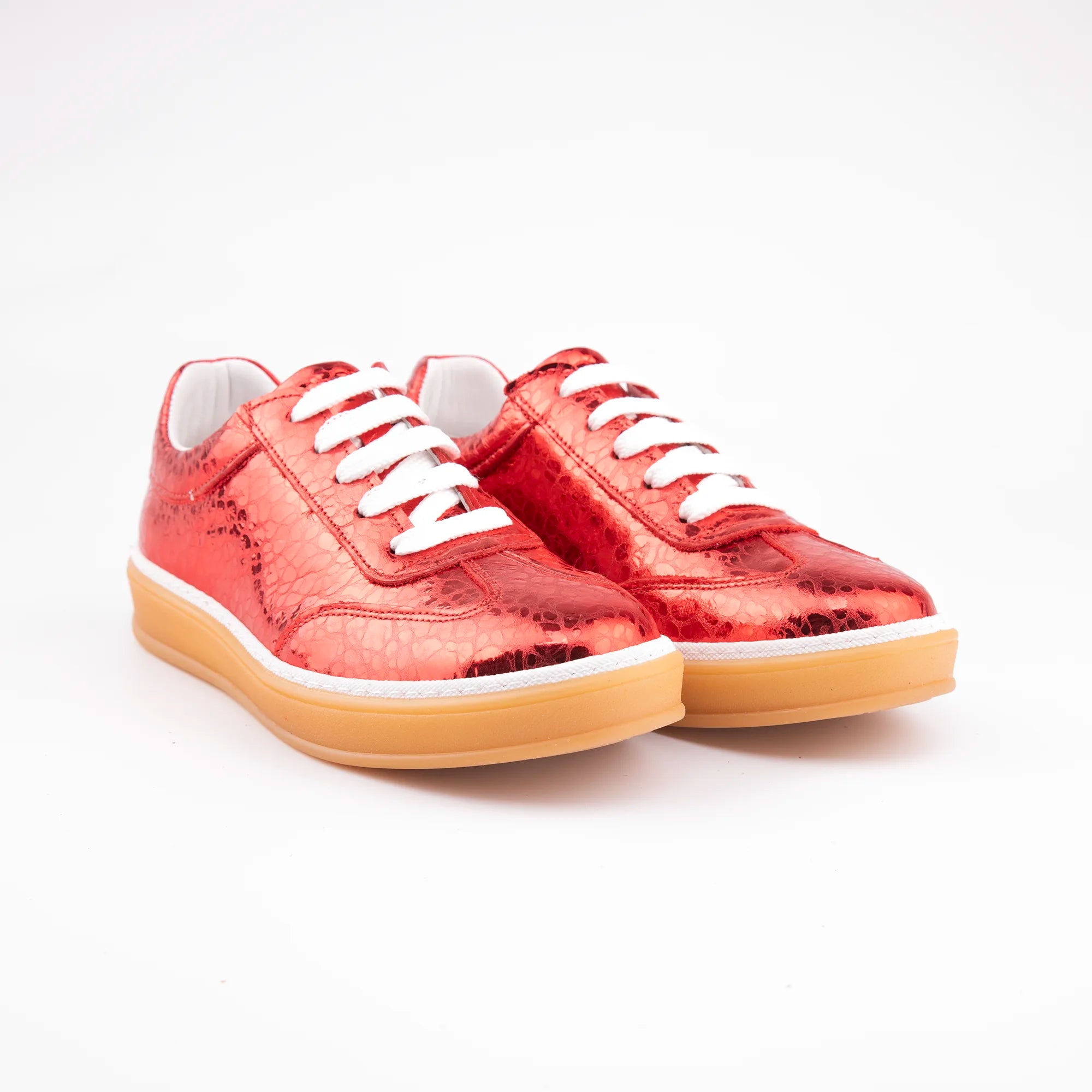 A pair of MrCalvano Redondo Beach Metallic Red Leather Women's Sneakers, featuring an embossed ruby red upper, crisp white laces, and a flat gum rubber outsole, photographed on a clean white background.