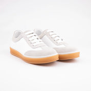 A pair of MrCalvano Redondo white leather casual shoes for women, featuring pale greige suede details and a natural gum sole, presented on a clean background.