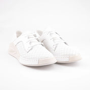 A pair of Santa Monica white leather women's sneakers, front-angled view, showcasing the precision stitching, the unique X-perforated leather panels, and the architectural sole design. The image emphasizes the clean white color and the subtle pale beige sole accents. This footwear is available in the United State market.