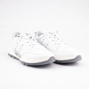 A pair of MrCalvano Venice Beach white leather women's sneakers, featuring a smooth white leather upper, a multi-layered off-white and light slate grey sole with subtle tread, and a metallic silver heel tab, presented on a minimalist white background.